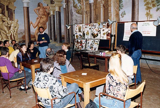 Participants take part in a lecture and visual workshop in a decorated hall in Cortona.